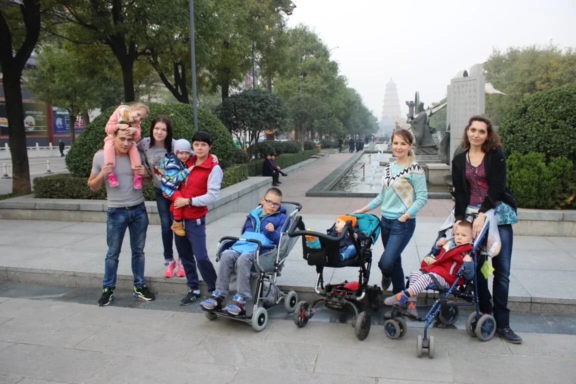 Семьи с колясками на прогулке по городскому бульвару